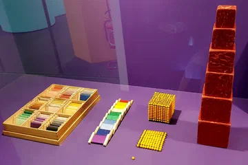 Materiales educativos tradicionales del método Montessori exhibidos en una muestra en Milán.